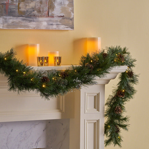 Blitzen Pine Lighted Garland – mixed fir and pine needles with pine cone clusters, snow powder, and 50 warm white flashing timer LEDs – Christmas Mercantile